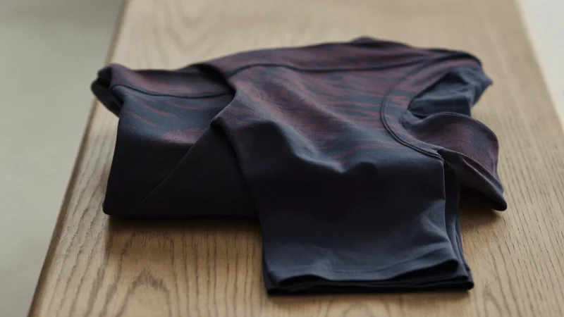 Gefaltete Kompressions-Tights auf einer hellen Eichenbank, seitlich fotografiert